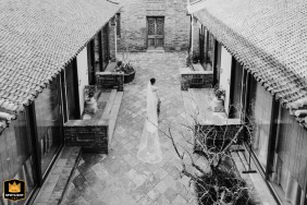 Outside from a high view above Shuanglong Lane, China, the bride's main gown is shown from behind, highlighting the elegant sweep of her dress as she stands before the wedding day unfolds.